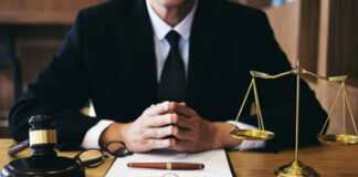 Avvo vs FindLaw vs Justia: Best Legal Directories Attorney in formal suit seated at wooden desk with gavel and scales of justice, illustrating professional legal directory listings and attorney visibility platforms.