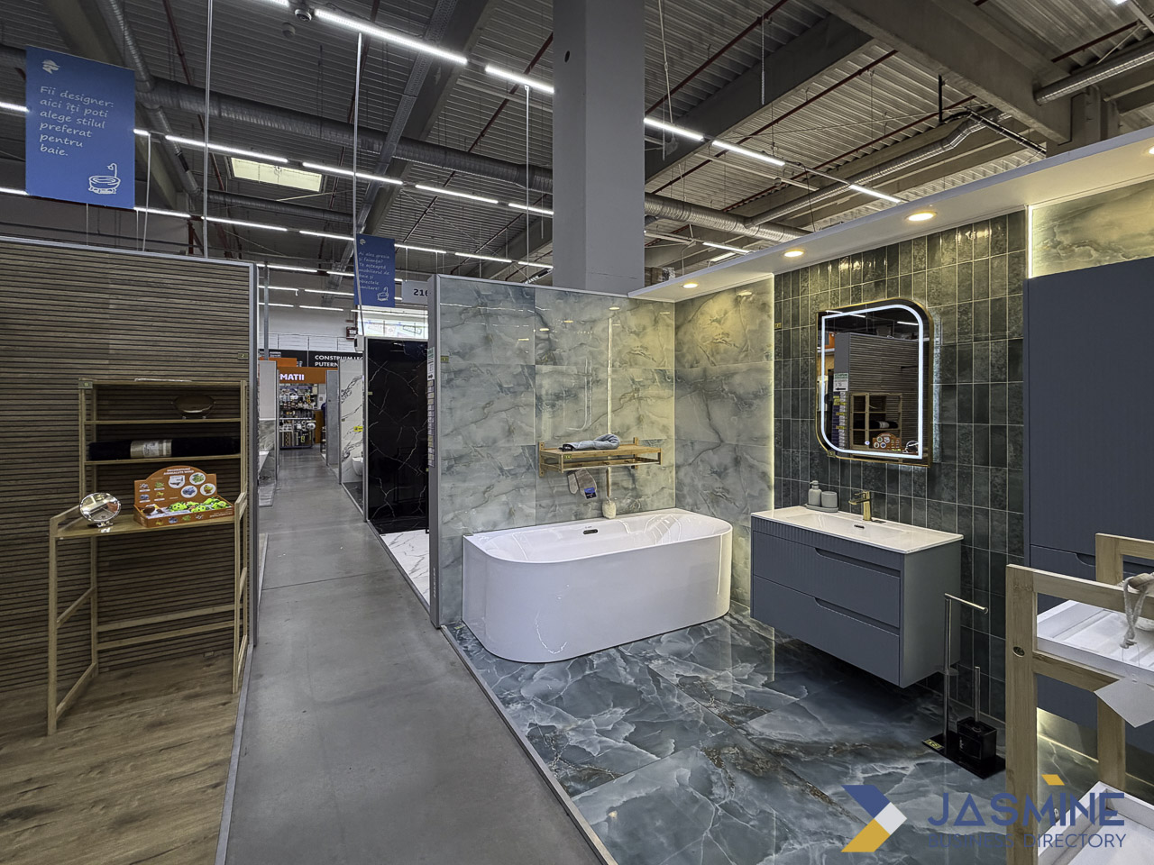 Modern bathroom showroom displaying a white freestanding tub, vanity, and tile samples, illustrating fixture options for homeowners planning bathroom refurbishments.