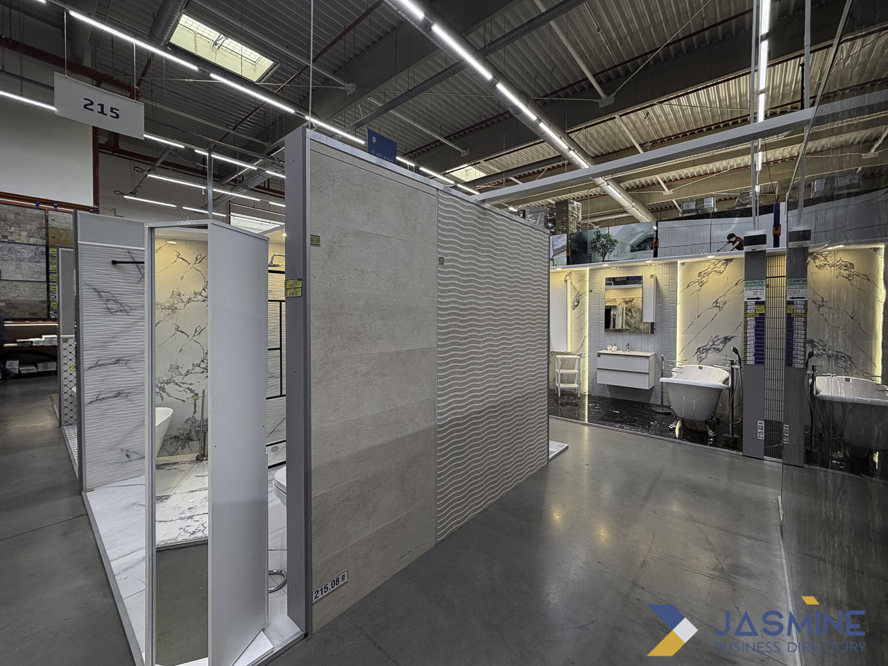 Interior of a bathroom fixture and tile showroom with illuminated display booths and product samples, representing the material selection phase of bathroom renovation planning.