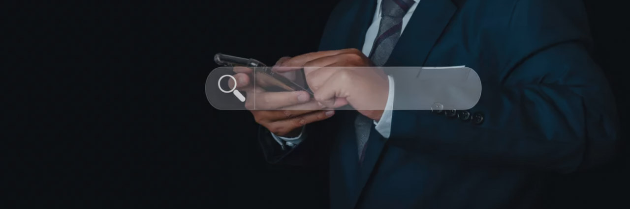 Business professional in suit holding smartphone with translucent search interface overlay, illustrating visual search technology for camera-based product discovery in retail environments.