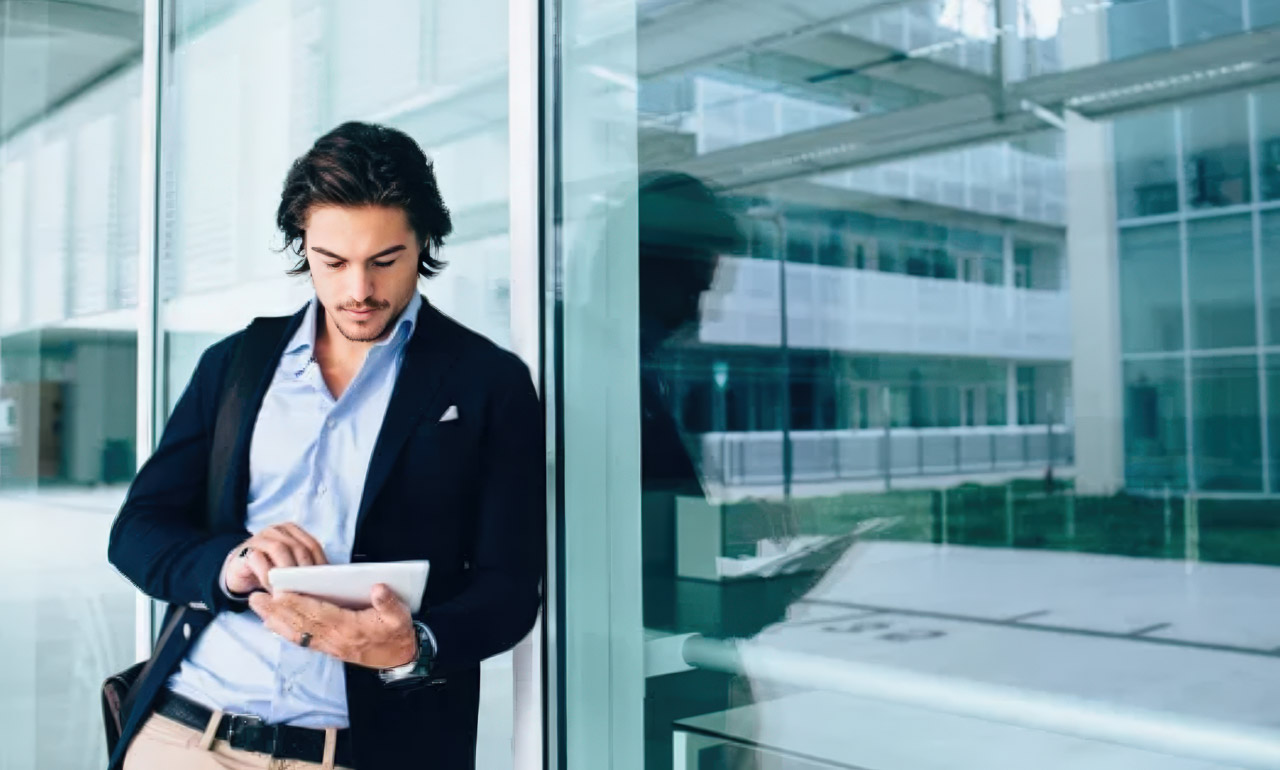 Business professional holding tablet by modern office windows, representing entrepreneurs building credibility through trusted online business directories and digital presence management.