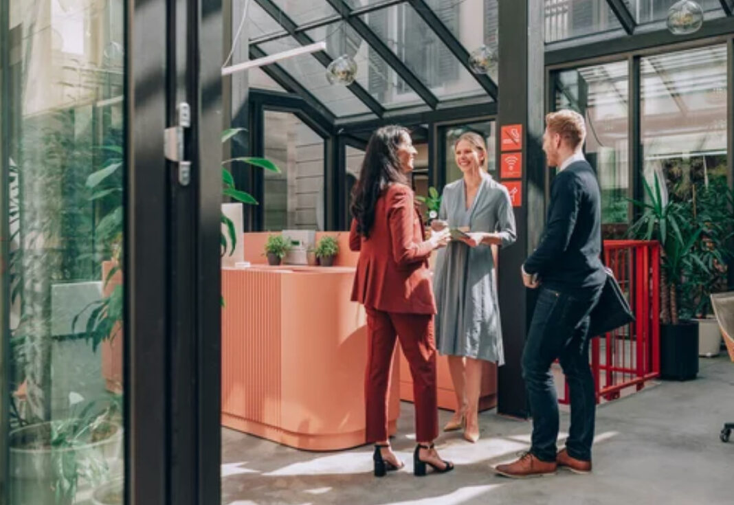 Modern reception area illustrates welcoming environment that helps attract customers Business professionals meet at a contemporary reception desk in a glass-roofed lobby, demonstrating the welcoming atmosphere that attracts customers to commercial spaces.