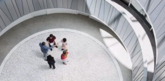 How to draw up a realistic budget for a major renovation Five business professionals stand in a circle within a modern spiral atrium, symbolizing collaborative infrastructure and systematic trust-building in organizational frameworks.