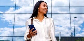 The role of advanced education in building solid management skills Business professional stands outside modern office building holding smartphone and notebooks, representing strategic preparation for Google's evolving search landscape.