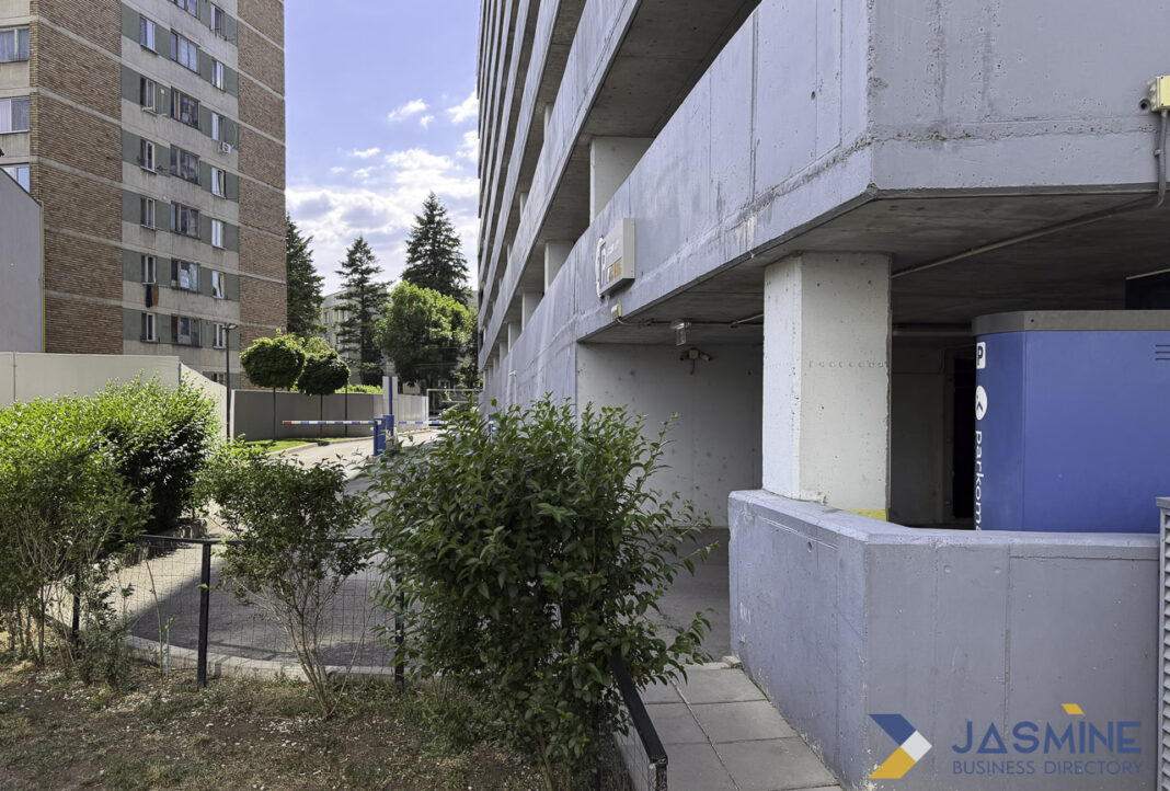Modern parking infrastructure uses license plate recognition technology for automated access control Concrete parking structure with exposed columns and paved courtyard in Timișoara, illustrating modern parking facilities where license plate recognition technology manages vehicle access.
