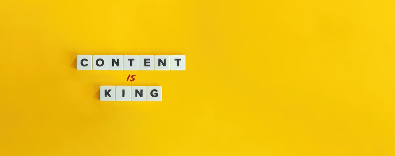 White letter tiles spelling 'CONTENT IS KING' with handwritten red script on yellow background, illustrating the central role of quality content in SEO strategy.