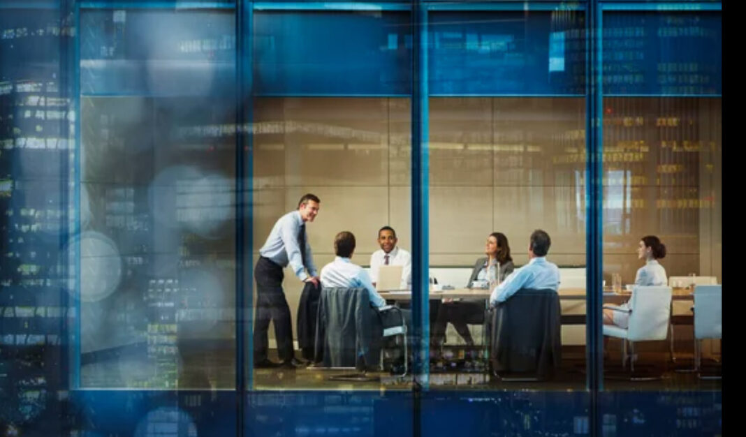 corporate-meeting-glass-walls-transparent-office-interior-business-professionals Business professionals meet in a glass-walled conference room, demonstrating the transparency and structural clarity essential to building trusted marketing infrastructure.