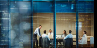 The Trust Stack: Building a Marketing Infrastructure that Survives Scrutiny Business professionals meet in a glass-walled conference room, demonstrating the transparency and structural clarity essential to building trusted marketing infrastructure.