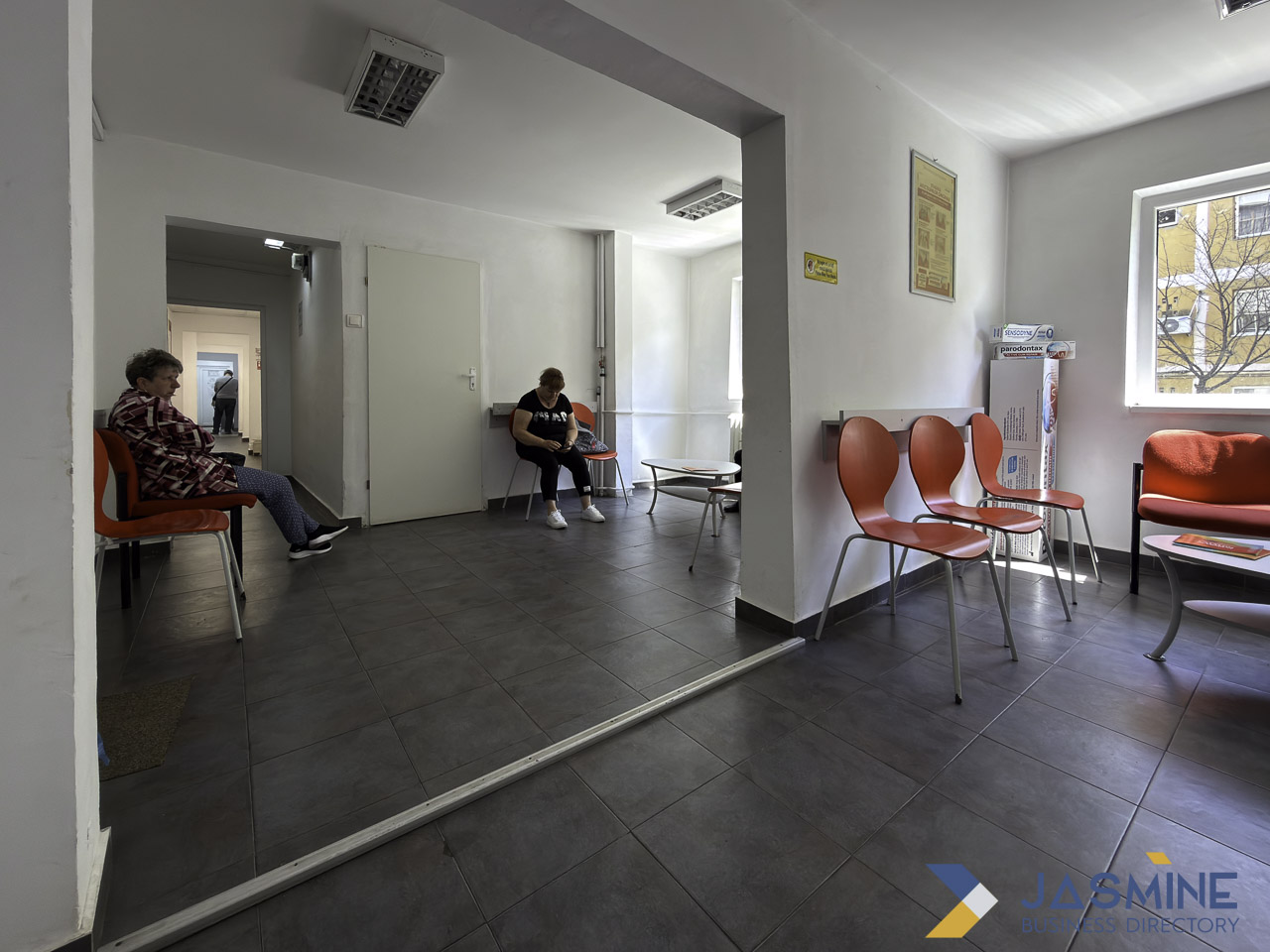 Modern dental office waiting room with orange chairs and seated patients in Timișoara, illustrating the clinical environment where preventive dental care begins.