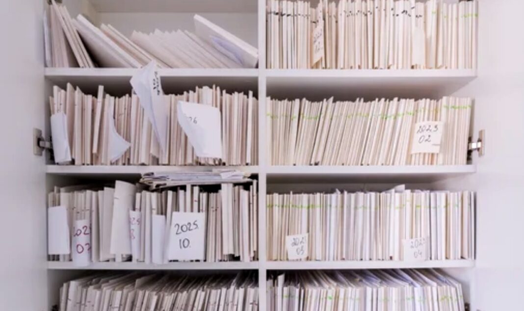 Organized document filing system illustrates industry-specific directory categorization strategy White shelving unit filled with organized papers and labeled file compartments, representing the systematic categorization approach used in industry-specific business directories.