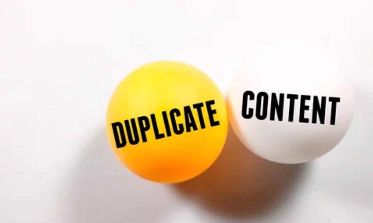 Two labeled spheres on white background, one reading 'DUPLICATE' and one reading 'CONTENT', illustrating the concept of duplicate content in SEO.