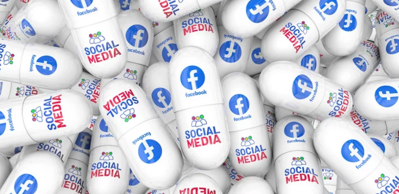 White capsules printed with Facebook logos and social media text scattered together, representing the consumption and integration of Facebook marketing strategies into business practices.