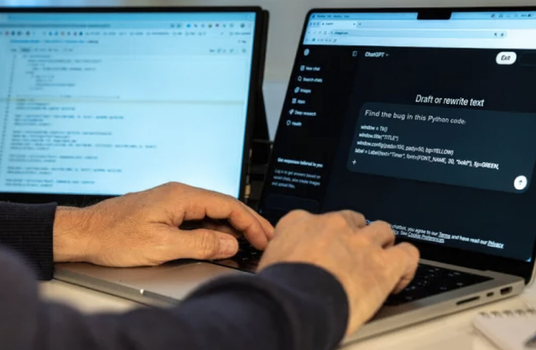 hands-typing-laptop-dual-monitors-chatgpt-programming-workspace Hands typing on laptop keyboard with dual monitors showing ChatGPT and code editor, representing self-directed technical SEO learning and implementation.