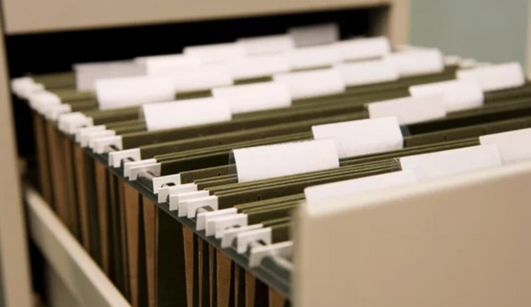 Traditional filing systems face evolution as digital directories reshape information organization Hanging file folders with white tabs organized in a storage drawer, illustrating traditional information organization methods in contrast to modern digital directories.
