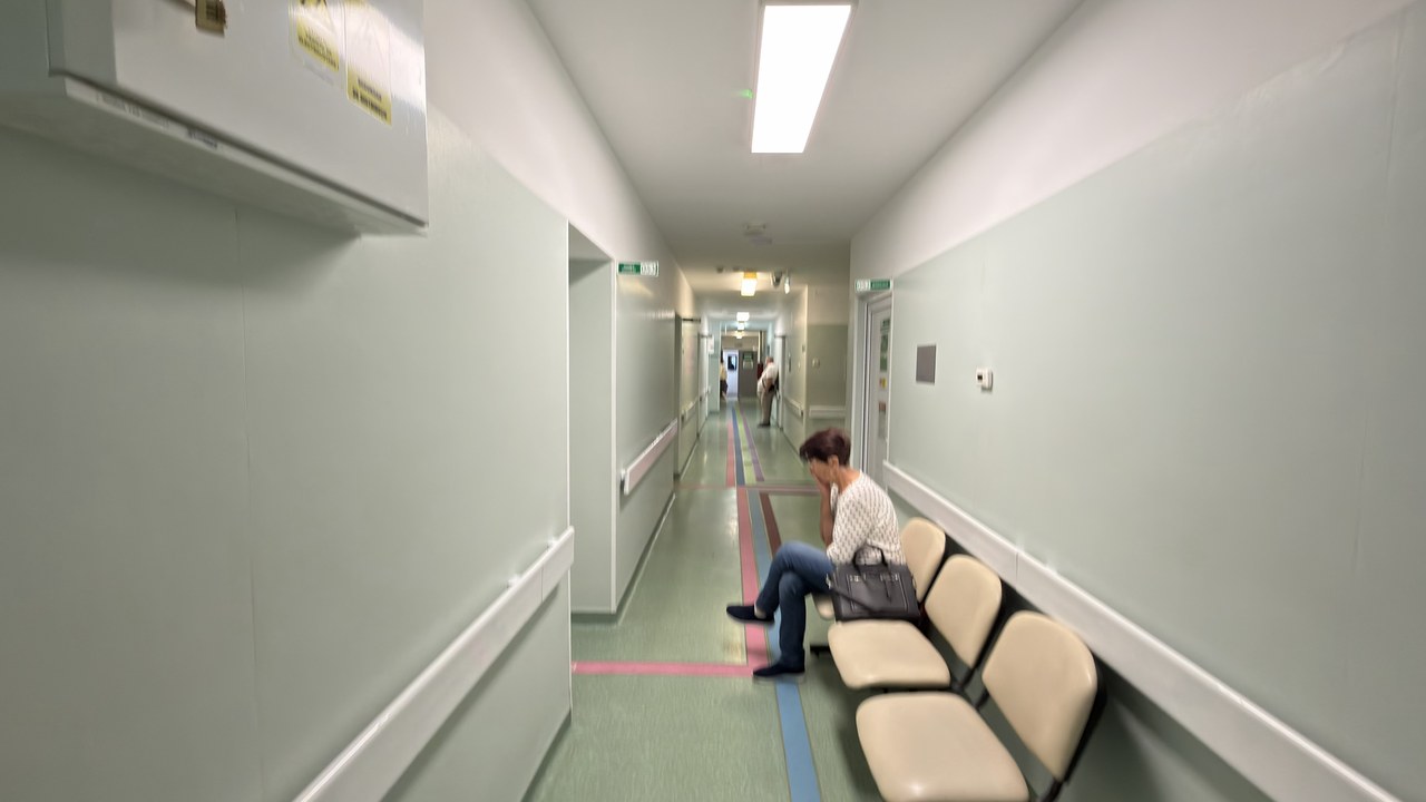 A modern hospital corridor with bench seating and striped flooring, representing the operational environment where healthcare leaders manage staff and facilities.