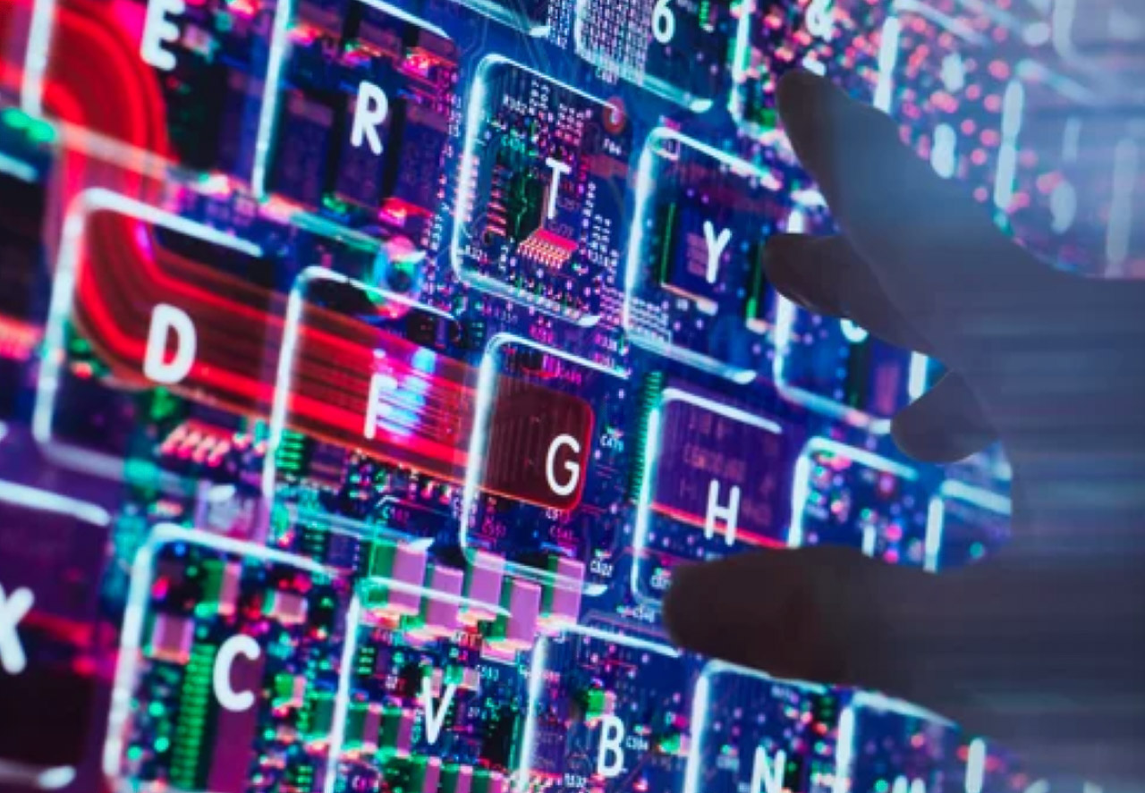 Close-up of an illuminated keyboard with visible circuit board components beneath transparent keys glowing in red, blue, and purple, representing the technical foundation of AI prompt engineering for SEO.