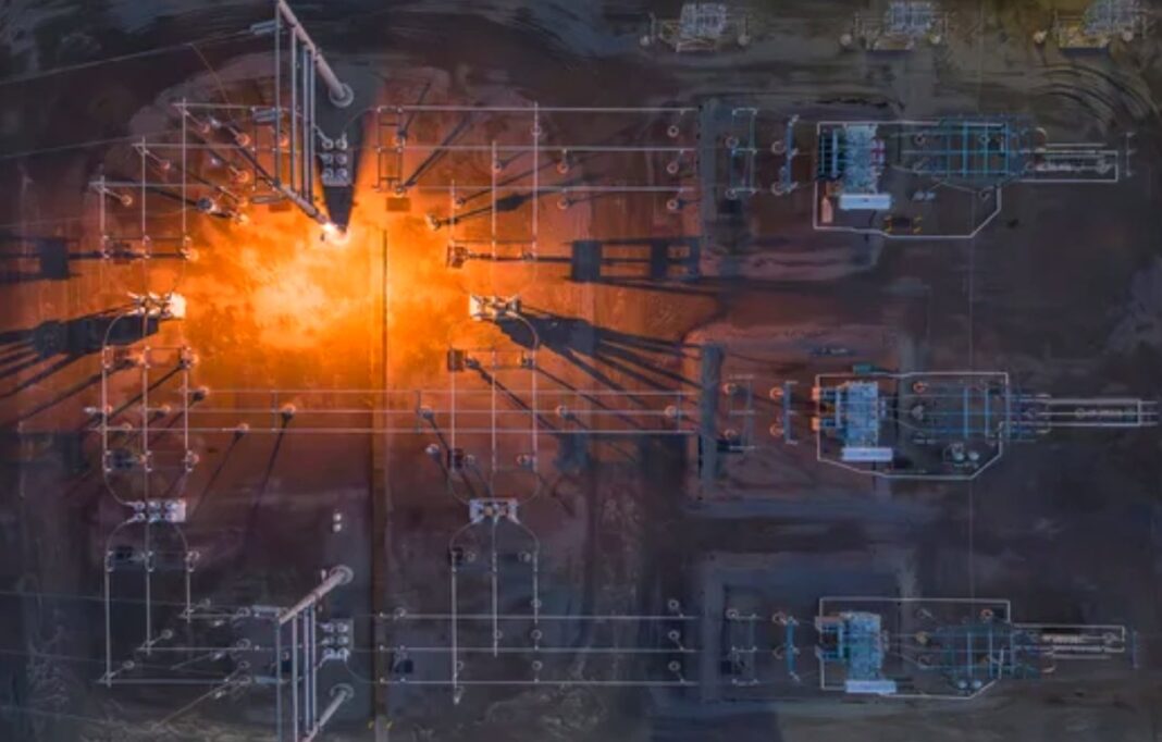 Advanced process visualization technologies supporting modern electrical engineering infrastructure Aerial view of an industrial facility with orange flare stack overlaid with blue technical wireframe diagrams, illustrating modern electrical engineering and infrastructure monitoring systems.