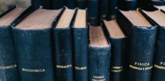 Dark blue hardcover scientific textbooks with Italian titles arranged on a library shelf, representing the systematic organization of academic resources in subject directories.