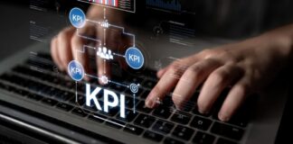 The Tools You Need for AI-Powered SEO Hands typing on a laptop keyboard with a holographic overlay showing KPI metrics and data visualizations, illustrating modern AI-powered SEO analysis tools.