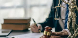 How Small Firms Win with Law Business Directories Wooden gavel and Lady Justice statue on a law office desk with attorney working in background, symbolizing small firms establishing professional presence.