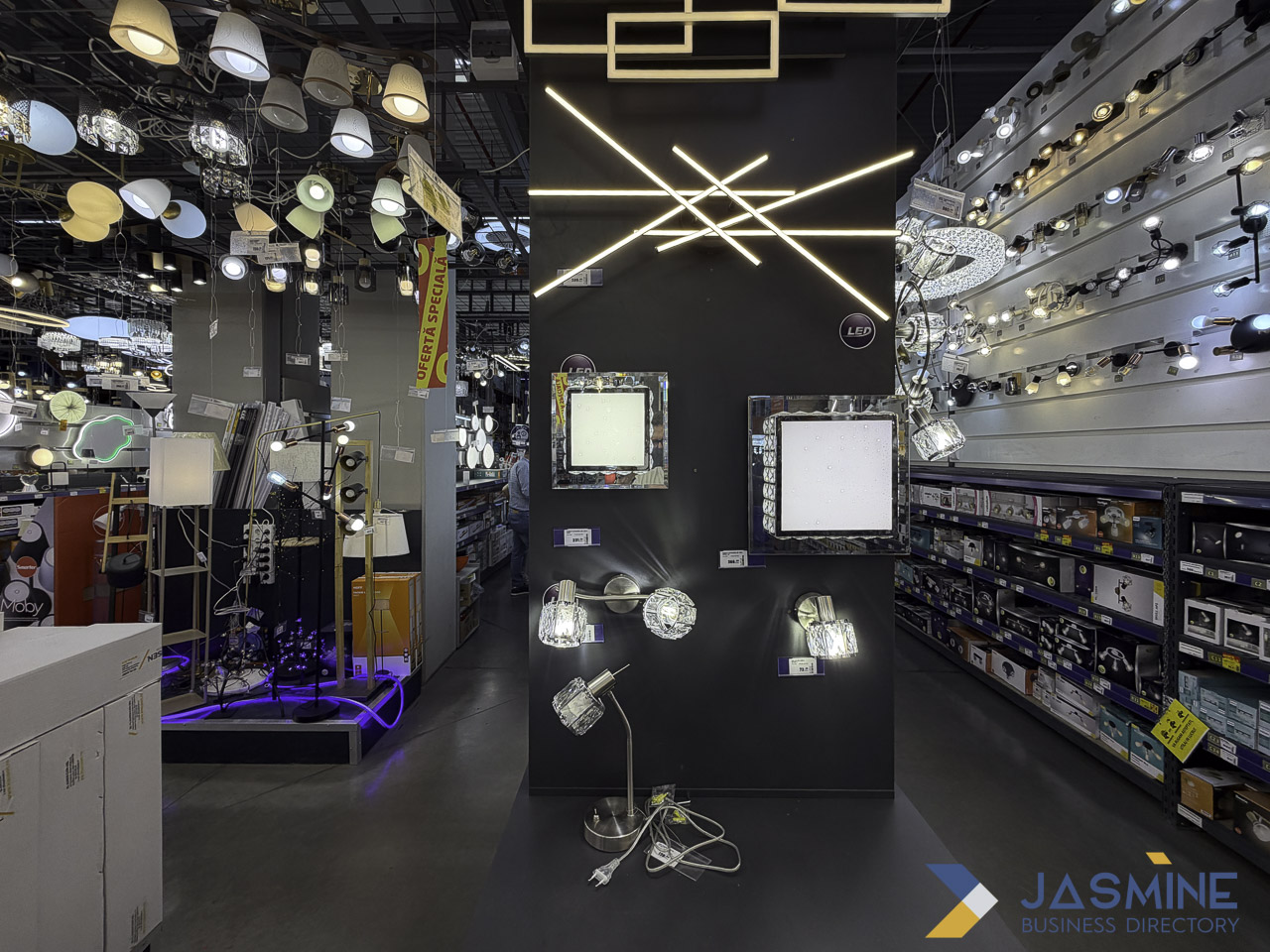 Modern lighting showroom interior in Timișoara features illuminated pendant fixtures and organized product displays, illustrating effective visual merchandising for business listings.