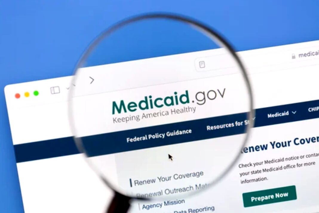 Medicaid website examined closely, representing government assistance programs that help reduce prescription costs Magnifying glass over Medicaid.gov website on computer screen, symbolizing examination of government assistance programs for reducing prescription medication costs.