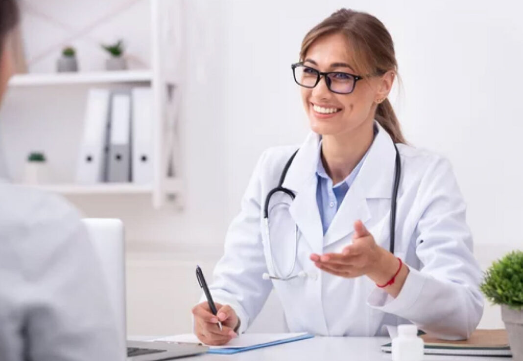 Healthcare expert exemplifies the shift from influencers to credentialed professionals in trusted business directories A medical professional in white lab coat with stethoscope consults at a clinical office desk, representing credentialed expertise in the modern professional landscape.