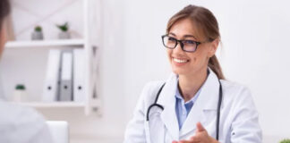 The Fall of Influencers and the Rise of “Expert Entities” A medical professional in white lab coat with stethoscope consults at a clinical office desk, representing credentialed expertise in the modern professional landscape.
