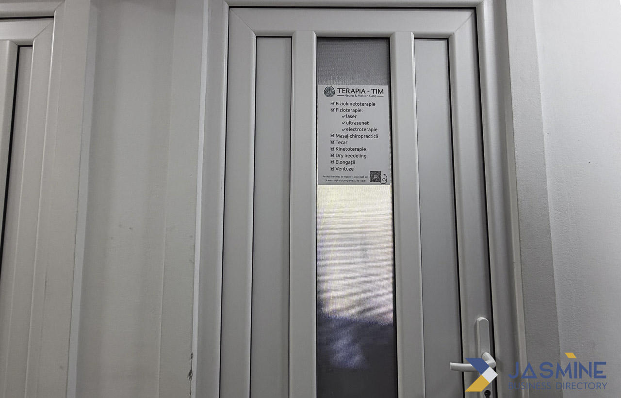 White framed door with frosted glass panel at a medical therapy office entrance in Timișoara, exemplifying the physical presence wellness businesses maintain to welcome local clients.