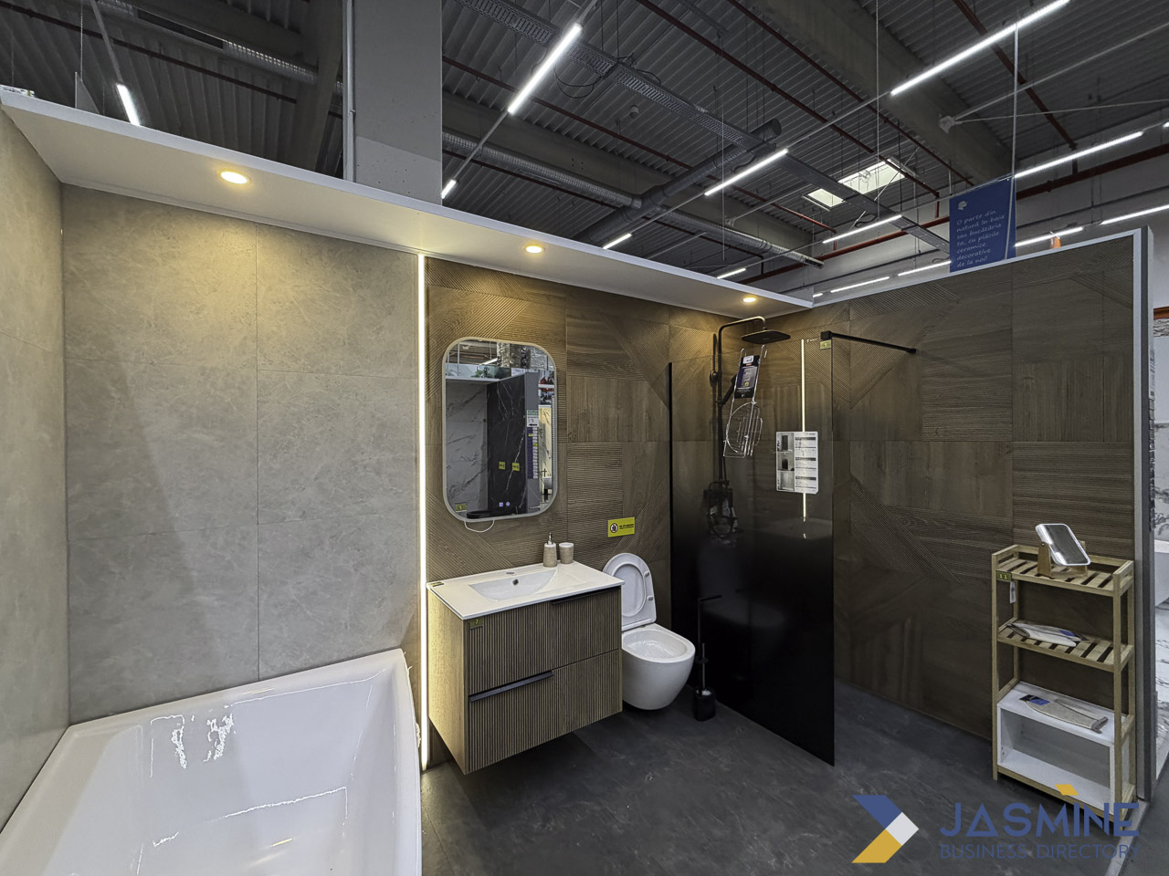 Modern bathroom showroom display with white bathtub, vanity, and glass shower enclosure, representing the fixture options homeowners consider when planning bathroom refurbishments.