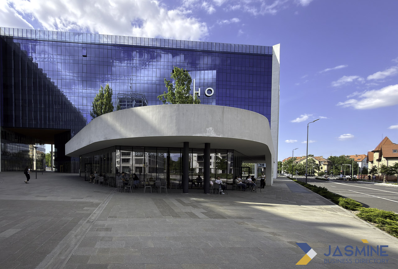 Modern curved pavilion and reflective glass office building in an urban commercial plaza, illustrating professional architectural photography for business directory listings.