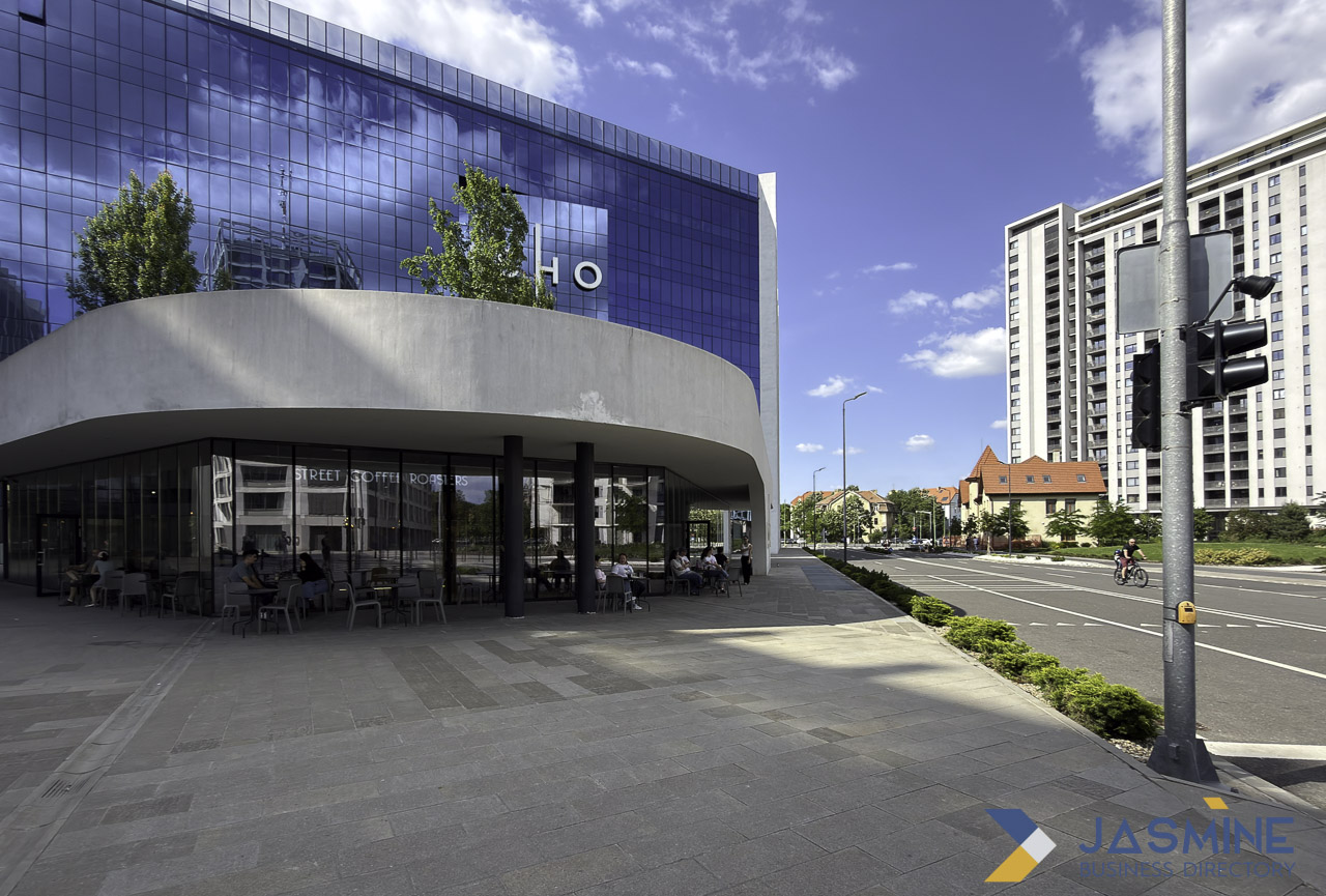 Contemporary commercial street in Timișoara with modern café and glass buildings, illustrating the neighborhood-level precision essential for effective local business directory listings.
