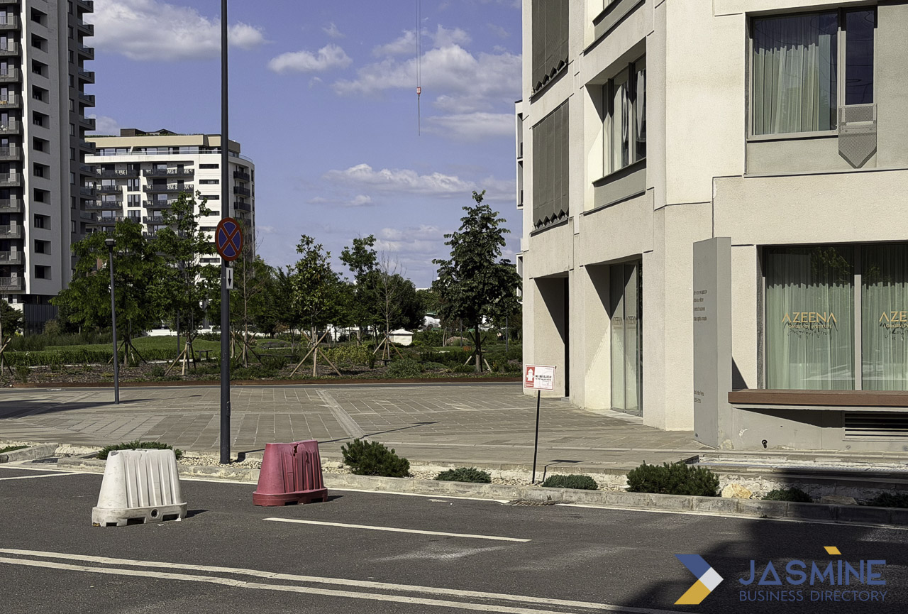 Modern mixed-use residential and commercial buildings line a paved street with parking and young trees, illustrating contemporary neighborhood development for location-based business pages.