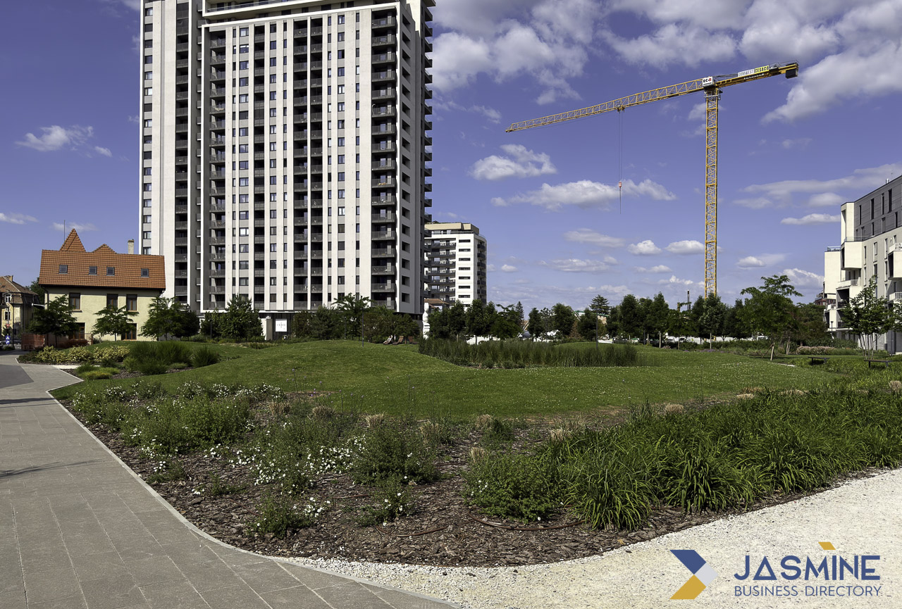 Modern high-rise residential towers with yellow construction crane and landscaped grounds in Timișoara illustrate hyperlocal real estate content for neighborhood SEO strategies.