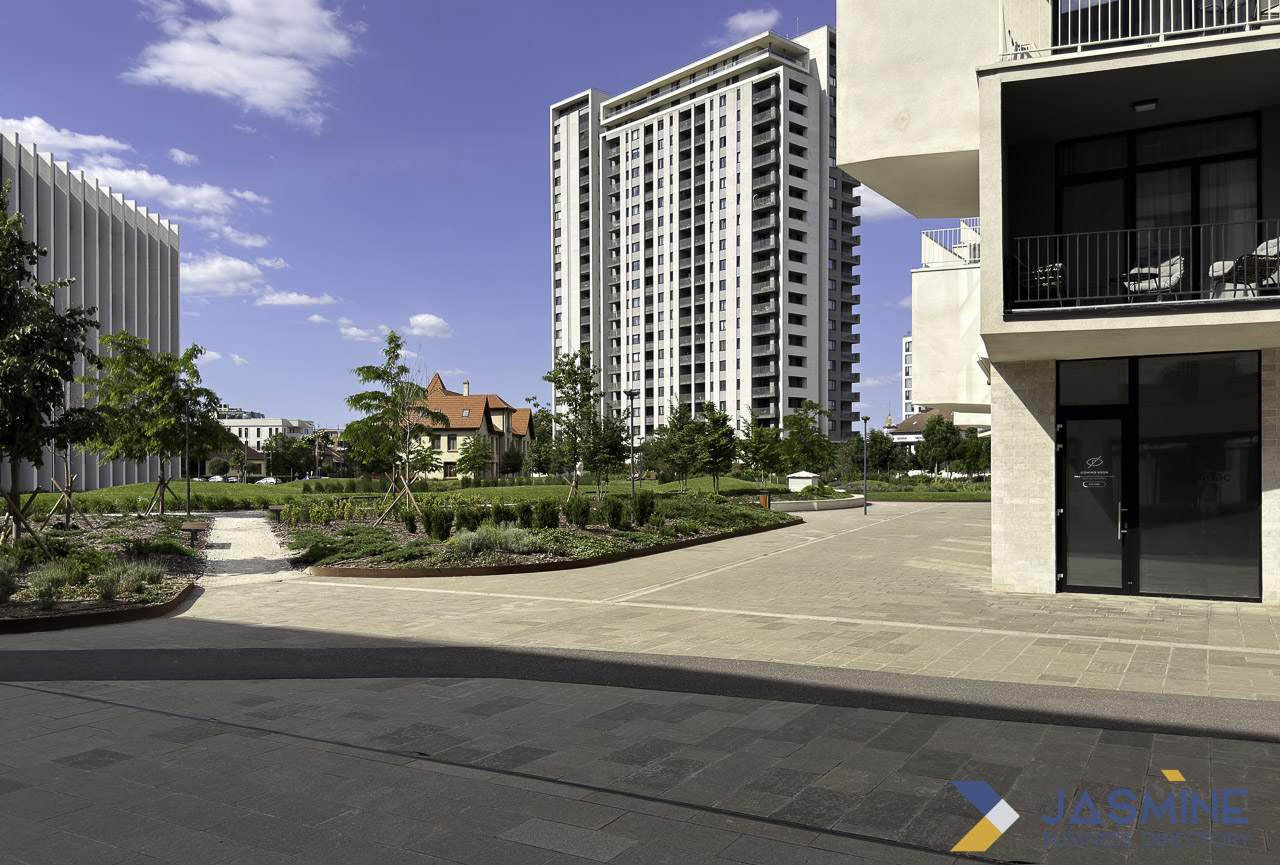 Modern white residential towers rise above landscaped walkways and young trees in Timișoara, exemplifying how architectural and outdoor design elements enhance contemporary properties.