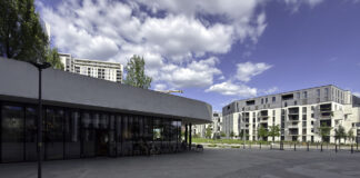 Modern urban plaza in Timișoara with curved glass pavilion and residential buildings, representing a community space where hyperlocal marketing strategies target neighborhood customers.