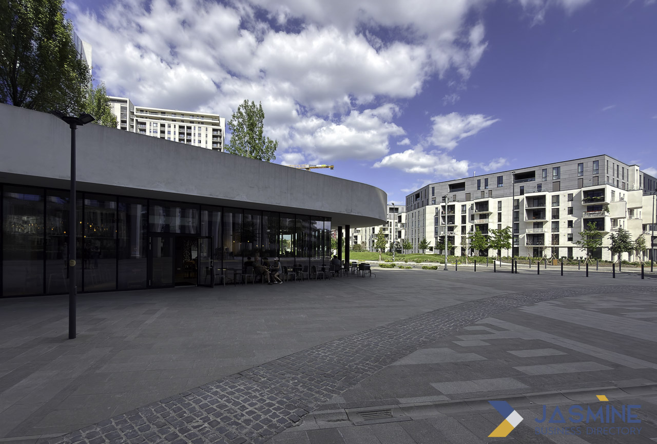 Modern urban plaza in Timișoara with curved glass pavilion and residential buildings, representing a community space where hyperlocal marketing strategies target neighborhood customers.