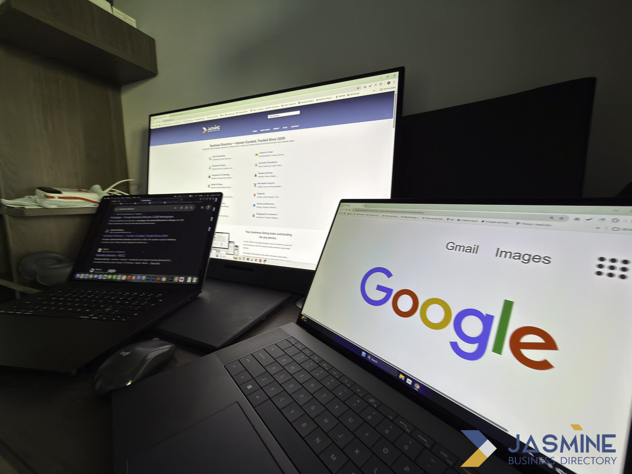 Three-screen computer workstation showing Google search, business directory website, and code editor, representing the digital tools that connect local businesses with global search platforms.