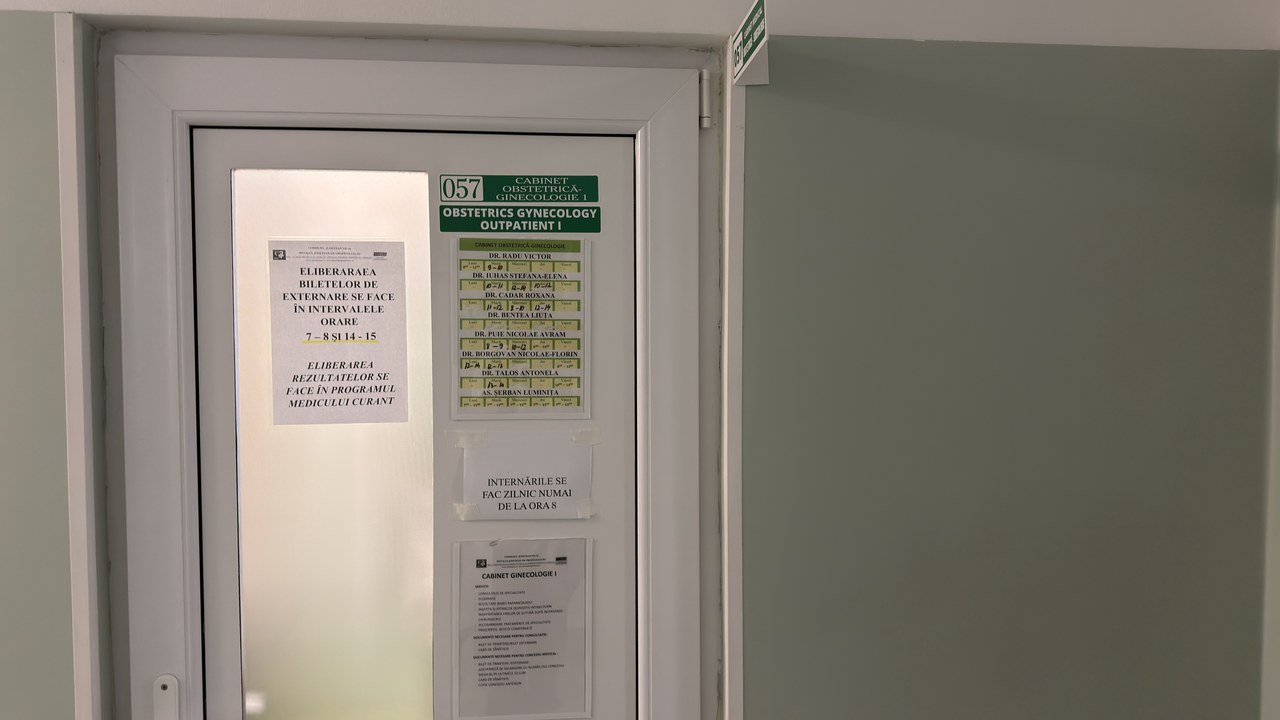 White door of an obstetrics-gynecology outpatient office with posted schedules and information sheets, illustrating healthcare provider directory listing practices.