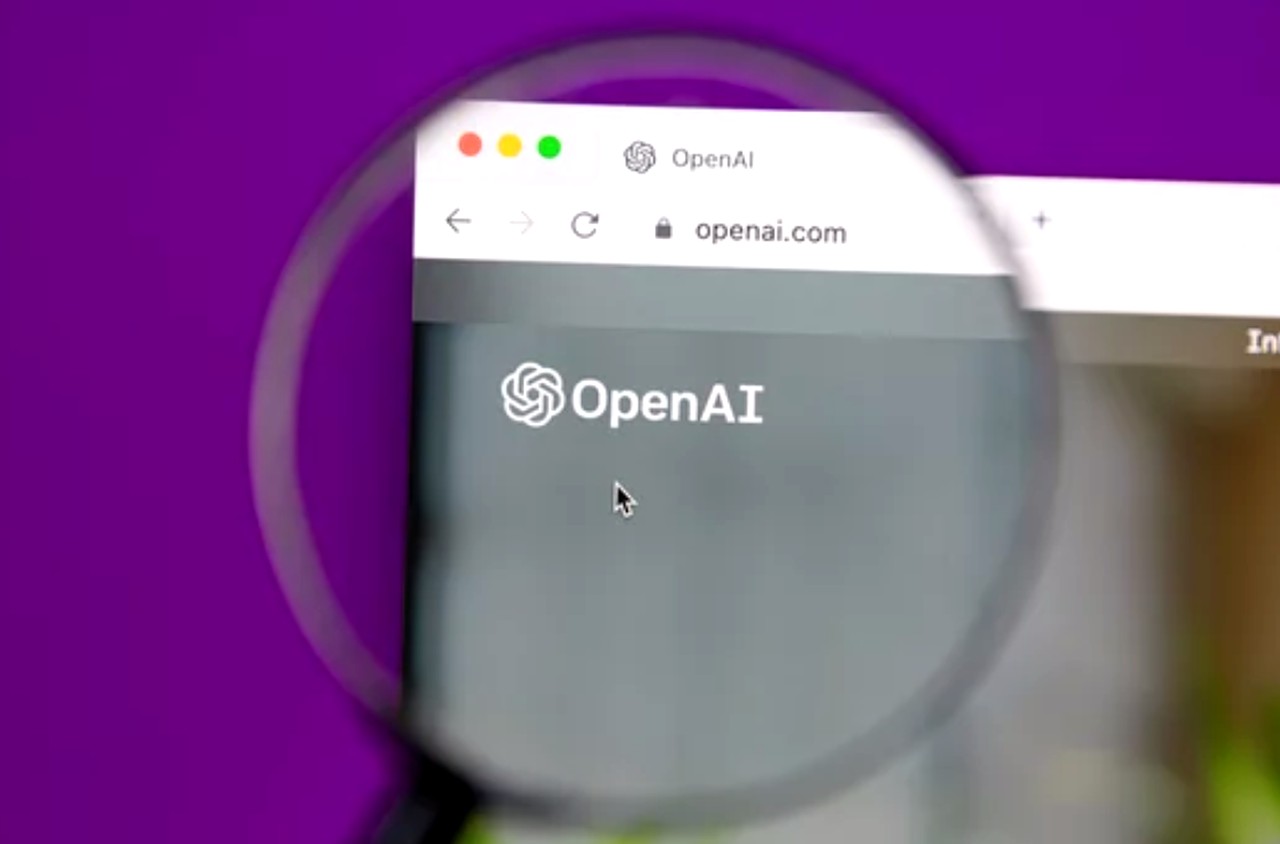 Magnifying glass enlarging the OpenAI homepage in a browser window, symbolizing the detailed examination needed for optimizing images for multimodal AI discovery.