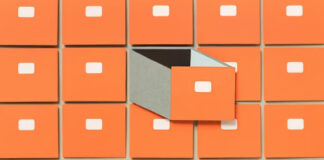 Orange filing cabinet drawers arranged in a grid with one drawer open showing compartments, symbolizing the organized categorization central to niche directory success.