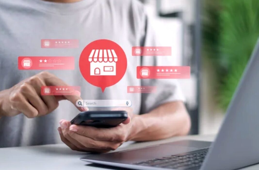 How customers engage with business directories and reviews through mobile devices Person holding smartphone with digital overlay showing storefront icon and five-star ratings, illustrating how customers submit reviews on business directories.