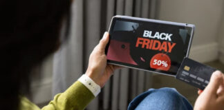 Person holds tablet showing promotional discount and credit card, representing the decision-making process when evaluating premium directory listing investments.