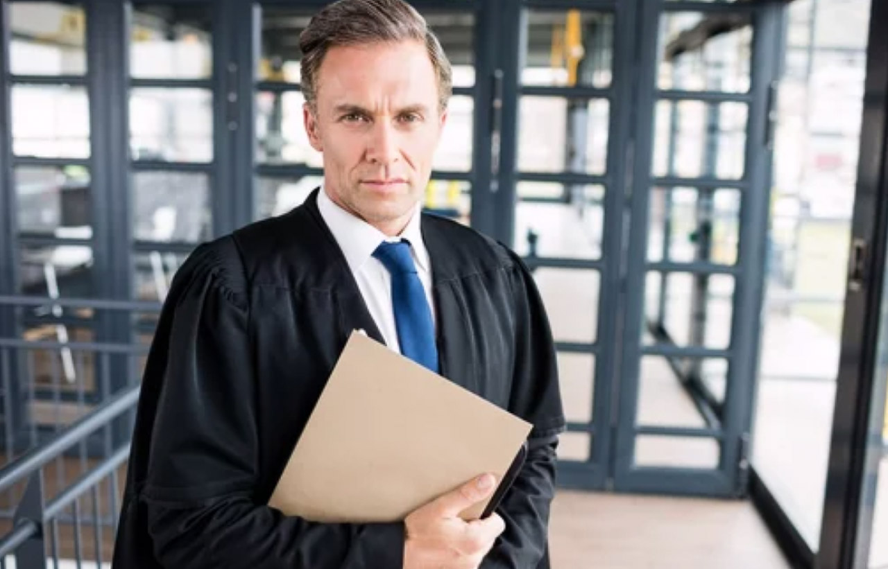 Professional man in black judicial robes holding a manila folder stands in an office setting, representing legal expertise in choosing business directories.