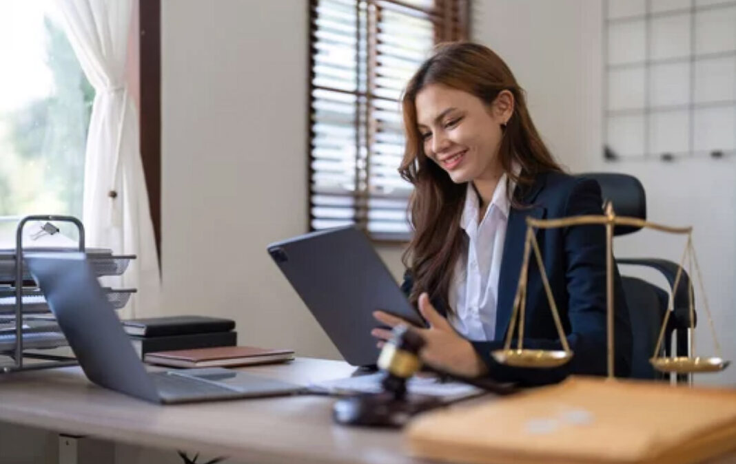 Professional reviewing legal documents symbolizes due diligence and credibility in trusted web directories Professional woman in business suit reviewing documents at desk with scales of justice and gavel, representing thorough verification and credibility in trusted directories.