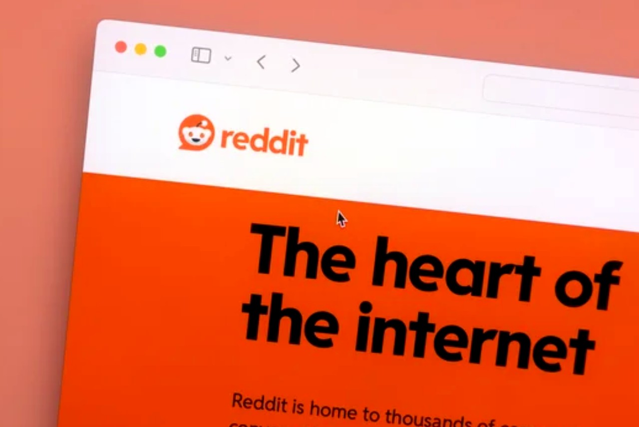 Computer screen showing Reddit homepage with orange logo and 'The heart of the internet' tagline, illustrating one platform in a Reddit versus Quora advertising comparison.