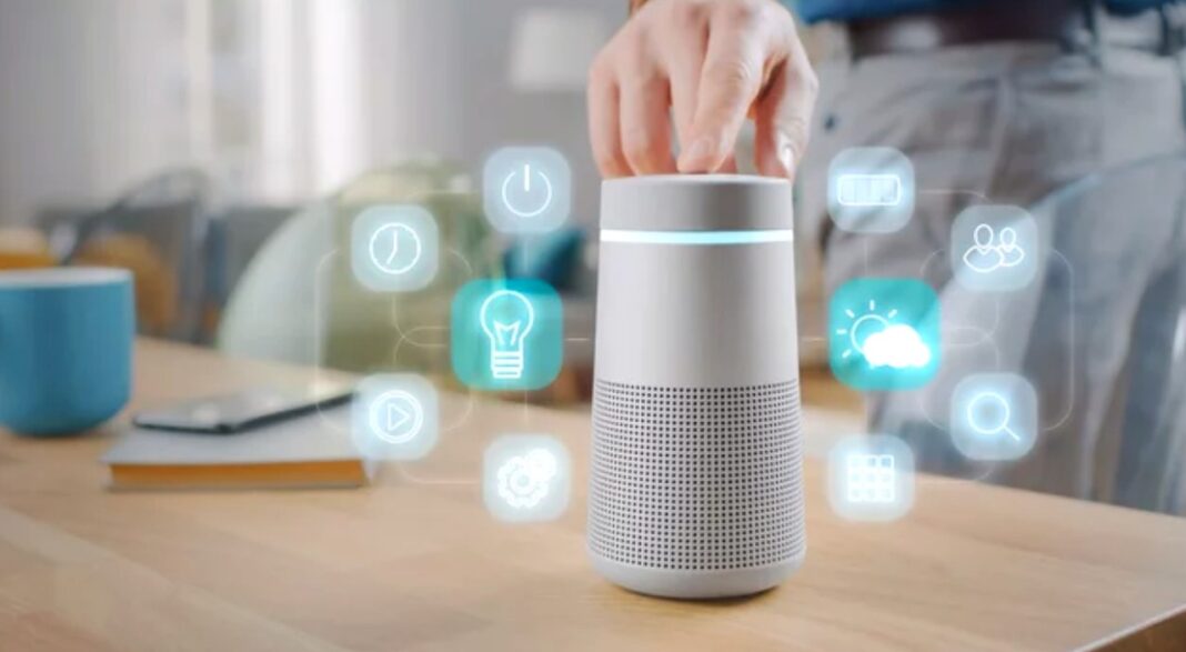 Smart speaker device demonstrates voice assistant interface for sound and voice branding marketing strategies Hand interacting with cylindrical smart speaker displaying holographic control icons on wooden table, illustrating voice-first technology for audio branding applications.