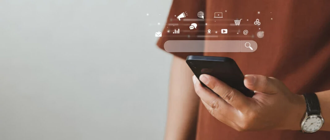 Digital interface overlay illustrates consumer interaction with advertising and social media content Person holding smartphone with translucent overlay of social media icons and search interface, representing the constant stream of digital advertising and notifications consumers face.