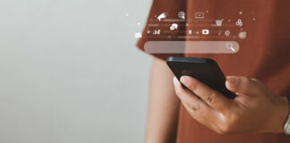 Person holding smartphone with translucent overlay of social media icons and search interface, representing the constant stream of digital advertising and notifications consumers face.