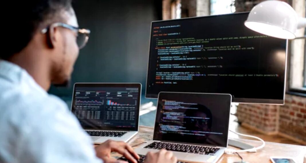 Professional analyzing data at multi-screen workstation exemplifies technical skills essential for future SEO success Developer working at multi-monitor workstation with code and data visualizations displayed, representing the analytical and technical skills required for modern SEO professionals.